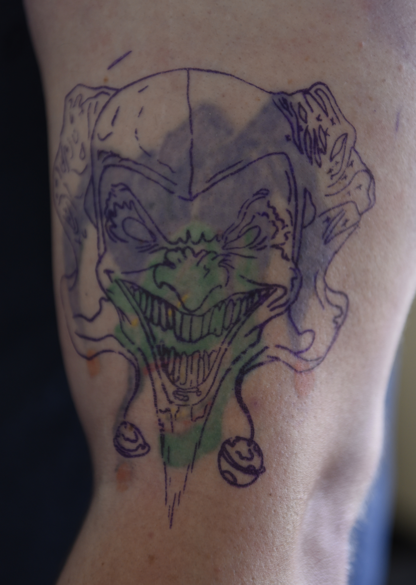 Craig Silvers gave himself his first tattoo, a court jester, on his left bicep. After lightening the original tattoo, still visible in the background, Daniel