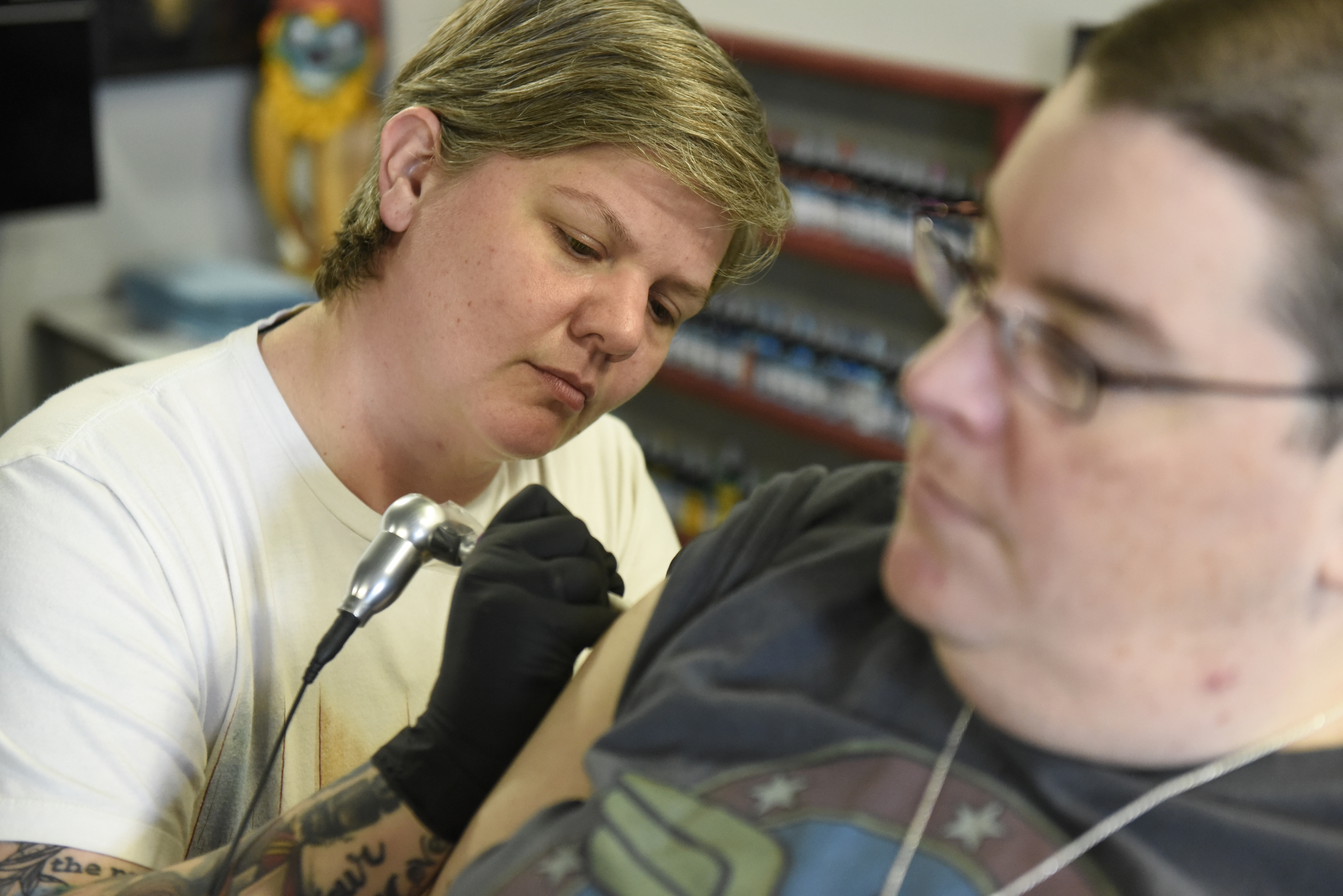 Jennifer Edge of Main Line Ink puts a tattoo on the bicep of customer Anita Latham on Thursday, Apr. 28, 2016, in Chattanooga, Tenn.