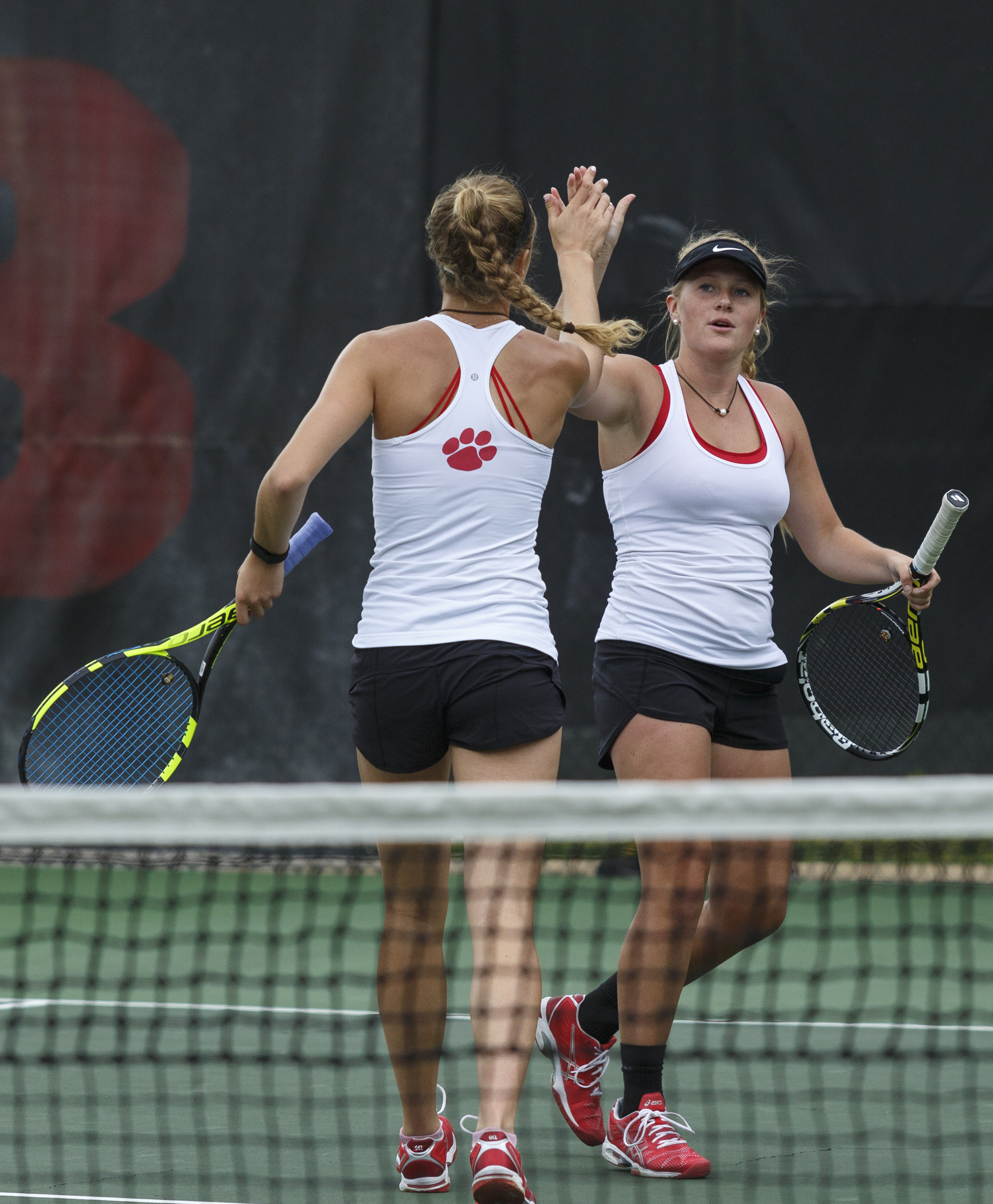 Baylor's Ashton Jenne, left, and doubles partner Presley Thomas high-five during their match against GPS's Corrinne Spann and Ellie Edwards on Wednesday at Baylor. Jenne and Thomas won the No. 2 match 8-2 to help the Lady Red Raiders earn the doubles point.