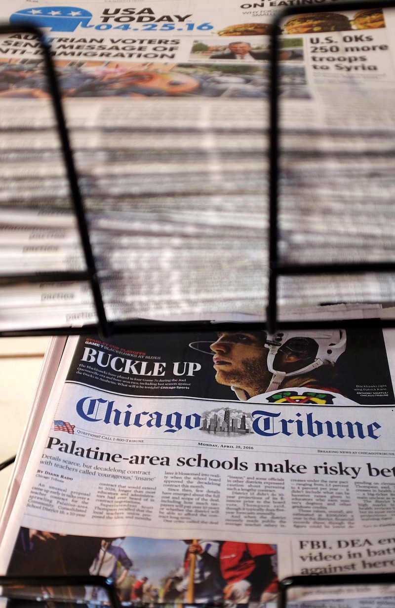 
              FILE - In this Monday, April 25, 2016, file photo, Gannett's USA Today, top, and Tribune Publishing's Chicago Tribune newspapers are displayed at Chicago's O'Hare International Airport. The Tribune Publishing Co. said Wednesday, May 4, 2016, it has rejected Gannett's more than $388 million bid to buy the business. (AP Photo/Kiichiro Sato, File)
            