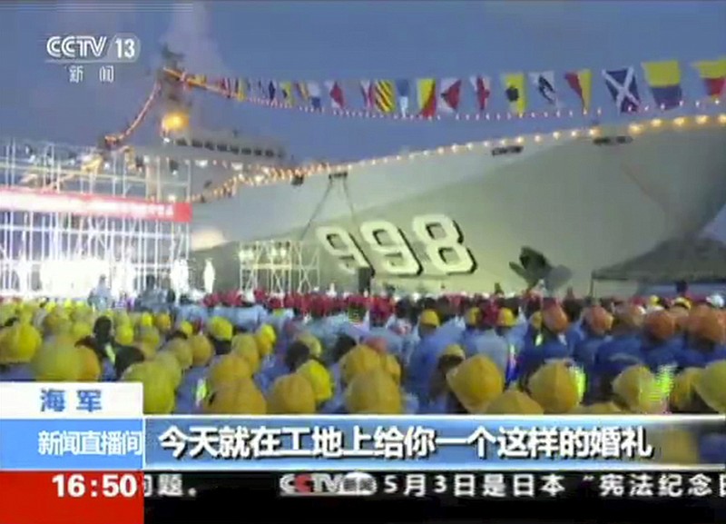 
              In this image taken from a video footage taken Monday, May 2, 2016 run by China's CCTV via AP Video, workers gather near a Chinese military ship during a performance for navy officers and construction workers on Fiery Cross Reef in the South China Sea. China's military this week sent a famed singer of patriotic anthems to perform before navy officers and construction workers on a newly created island in a disputed section of the South China Sea, underscoring its growing confidence in asserting its maritime claims. (CCTV via AP Video)  CHINA OUT, NO SALES, NO ARCHIVES, EDITORIAL USE ONLY
            