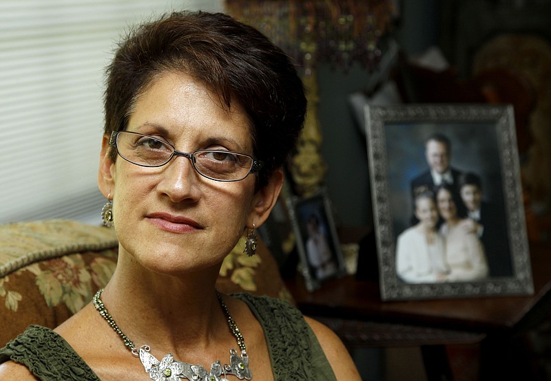 
              FILE- In this Aug. 11, 2011, file photo, Lorie Van Auken poses for The Associated Press in her East New Brunswick, N.J. home. Fifteen years after Van Auken lost her husband, Kenneth Warren Van Auken, in the Sept. 11 attacks,  Van Auken thinks she still hasn't been told the whole truth about 9/11. She wants to know what's in 28 classified pages locked away in a basement room in the U.S. Capitol which describe investigative leads about "specific sources of foreign support" for the terrorists. (AP Photo/Julio Cortez, File)
            