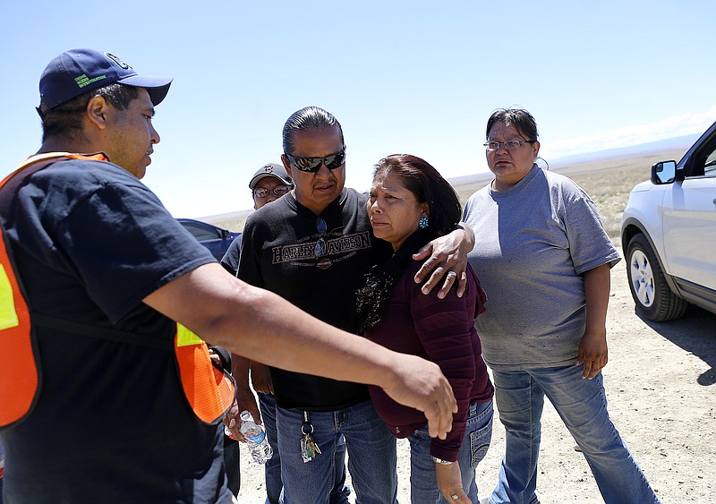 Family and friends gather along Navajo Route 13 south of Shiprock, N.M., Tuesday, May 3, 2016, just a few miles from where Ashlynne Mike's body was discovered. Authorities are poring over parts of the Navajo Nation in search of the man who snatched Ian and Ashlynne Mike and killed Ashlynne. Tips are flooding in from across the reservation that spans parts of New Mexico, Arizona and Utah as well as the close-knit tribal community where Ashlynne lived.