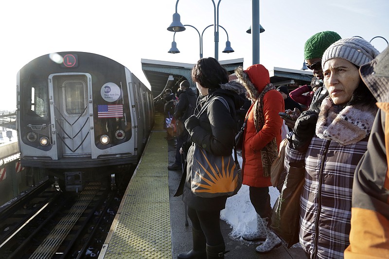 
              FILE - In this Jan. 25, 2016 file photo, commuters wait as an L train arrives at the Broadway Junction subway station in the Brooklyn borough of New York. The lone subway tunnel connecting some of Brooklyn's hippest, youngest neighborhoods to New York City's commercial heart in Manhattan will either be closed entirely for 18 months, or see extremely limited service for three years, under two possible plans for repairing damage caused by Superstorm Sandy. Work on the L line would start in 2019. (AP Photo/Mark Lennihan, File)
            