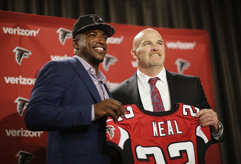 Atlanta Falcons first-round draft pick Keanu Neal, left, poses for a photo with his jersey and head coach Dan Quinn following a news conference at the football team's practice facility Friday, April 29, 2016, in Flowery Branch, Ga. (AP Photo/David Goldman)