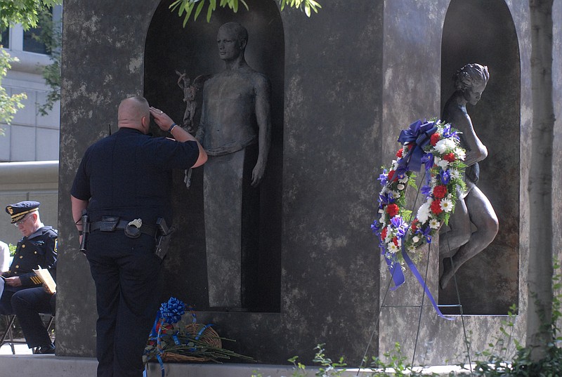 A local law enforcement officer salutes the Law Enforcement Memorial on Market Street in a previous ceremony.