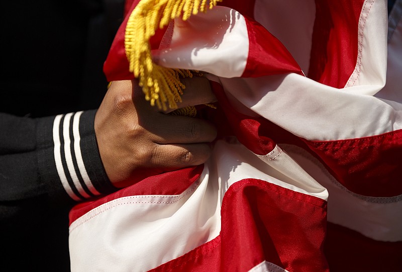 A U.S. Naval Sea Cadet holds an American flag before the Armed Forces Day Parade on Friday, May 6, 2016, in Chattanooga, Tenn. This was the first Armed Forces Day Parade since last July's shootings at military facilities in which five service members were killed.