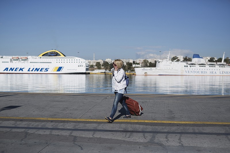 
              A woman carries her luggage in front of docked ferries on strike at the port of Piraeus, near Athens, on Friday, May 6, 2016. Services have ground to a halt in Greece as workers start a three-day general strike protesting new bailout austerity measures they say will further decimate incomes, in a sign of growing discontent with the left-led coalition government. (AP Photo/Petros Giannakouris)
            