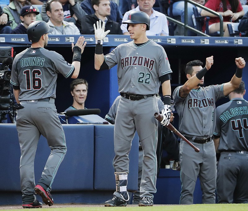 Arizona Diamondbacks' Chris Owings, left, is high-fived by teammate Jake Lamb after scoring off a single by Nick Ahmed in the second inning of a baseball game against the Atlanta Braves, Friday, May 6, 2016, in Atlanta. (AP Photo/David Goldman)