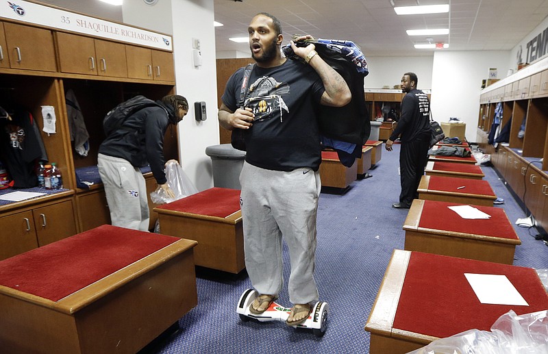 Tennessee Titans defensive end Jurrell Casey rides a scooter board out of the locker room Monday, Jan. 4, 2016, in Nashville, Tenn. The Titans finished the season 3-13 and announced Monday that the contract of general manager Ruston Webster will not be renewed and interim head coach Mike Mularkey will be among those interviewed for the permanent head coaching position. (AP Photo/Mark Humphrey)