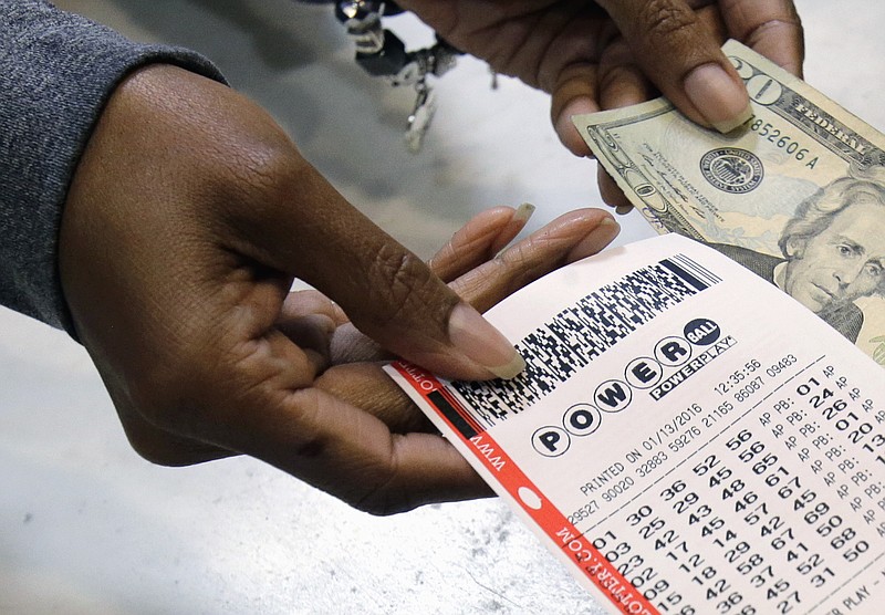 
              FILE - In this Jan. 13, 2016 file photo, a clerk hands over a Powerball ticket for cash at Tower City Lottery Stop in Cleveland. Powerball estimates that its jackpot for the May 4, 2016, drawing is $348 million. (AP Photo/Tony Dejak, File)
            