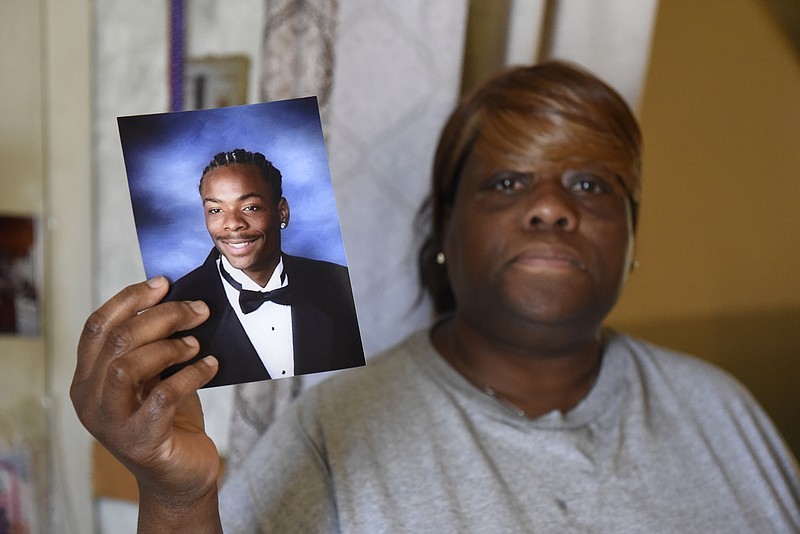 Patricia McCrary is seen in her apartment on Monday, Mar. 28, 2016, in Chattanooga, Tenn., holding a photograph of her 19-year-old son Tyrone Stewart, Jr., who was shot and killed at a party on Dodds Avenue in 2008. The shooting occurred in front of a number of people, but no one has stepped forward as a witness and so no one has been prosecuted in the case. 