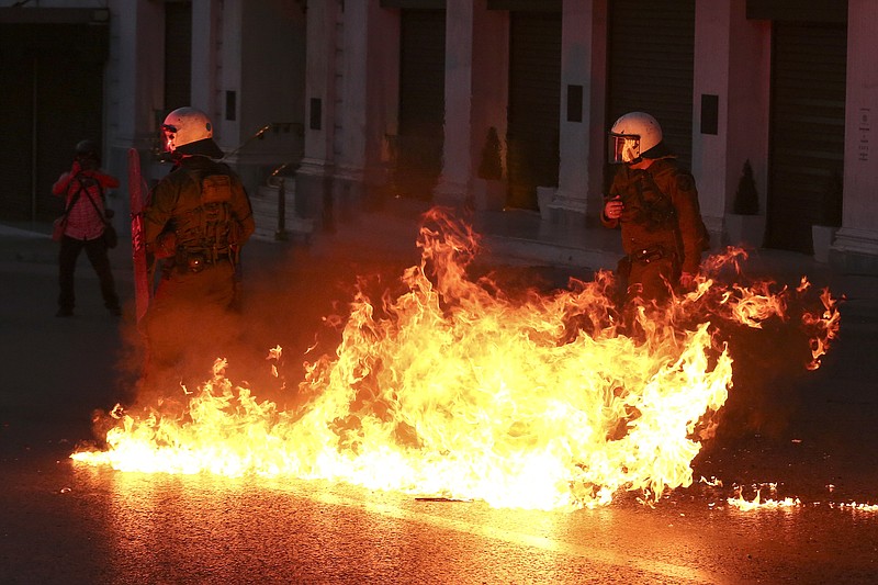 
              A petrol bomb explodes in front of policemen during clashes in Athens, on Sunday, May 8, 2016. Protesters in Greece have hurled firebombs and other projectiles at police in front of parliament before a controversial vote on an austerity bill. (AP Photo/Yorgos Karahalis)
            