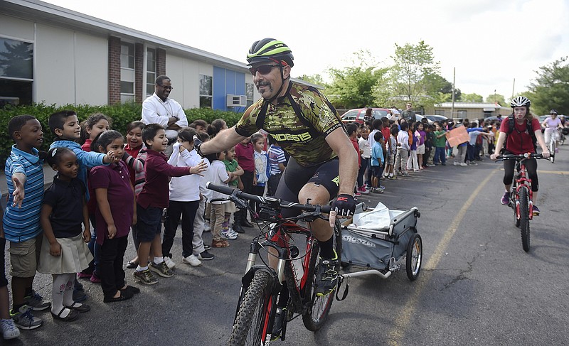 
              In this April 22, 2016 photo, volunteer Dave Perreault high fives students during a book delivery by Ride for Reading to students at Haywood Elementary School in Nashville, Tenn. Ride for Reading puts books in the hands of low-income children via bicycle, promoting literacy and healthy living. (Samuel M. Simpkins/The Tennessean via AP) NO SALES; MANDATORY CREDIT
            