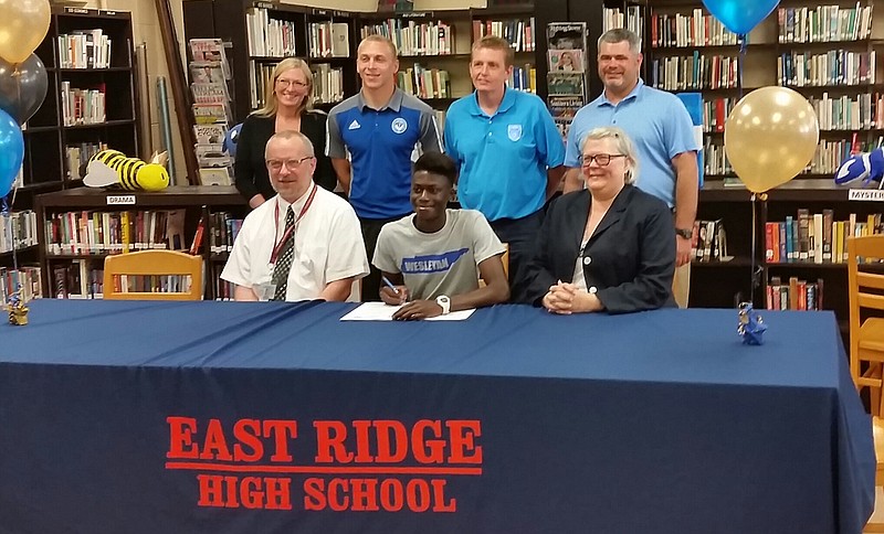East Ridge High School senior Hunter Schobert, seated center, signs scholarship papers to play soccer for Tennessee Wesleyan College.