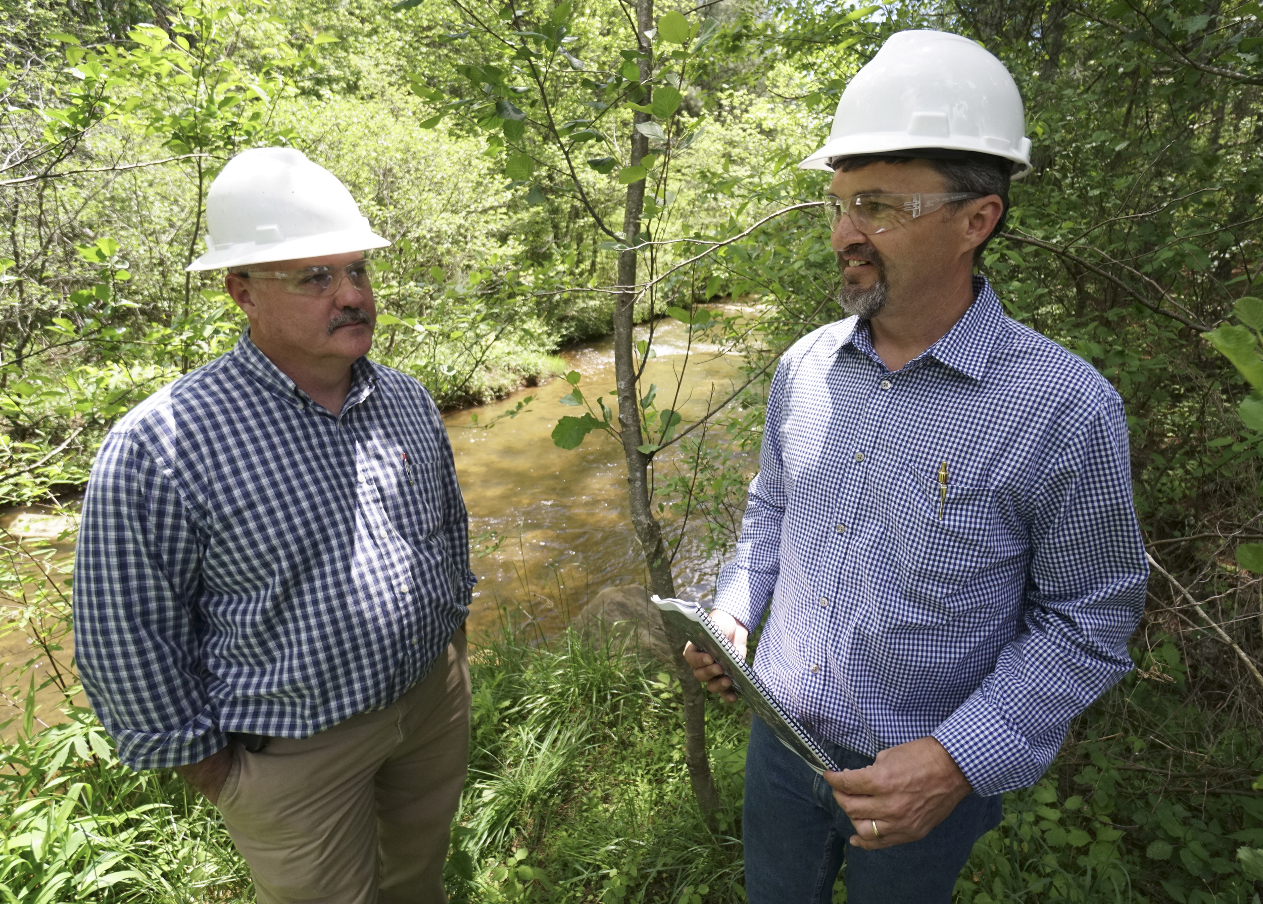 Scott Deal, left, listens as Rick Passmore, project manager, speaks about progress made to the Eureka Roast Yard and North Potato Creek areas in the Copper Basin.