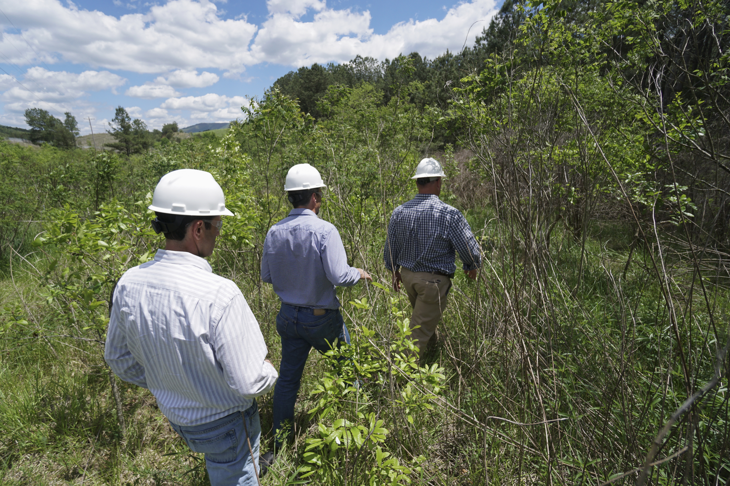 Eric Moses, Director of Communications and Public Affairs with the Occidental Petroleum Corporation and project manager Rick Passmore follow site manager Scott Deal into the Eureka Roast Yard and Potato Creek area in the Copper Basin.