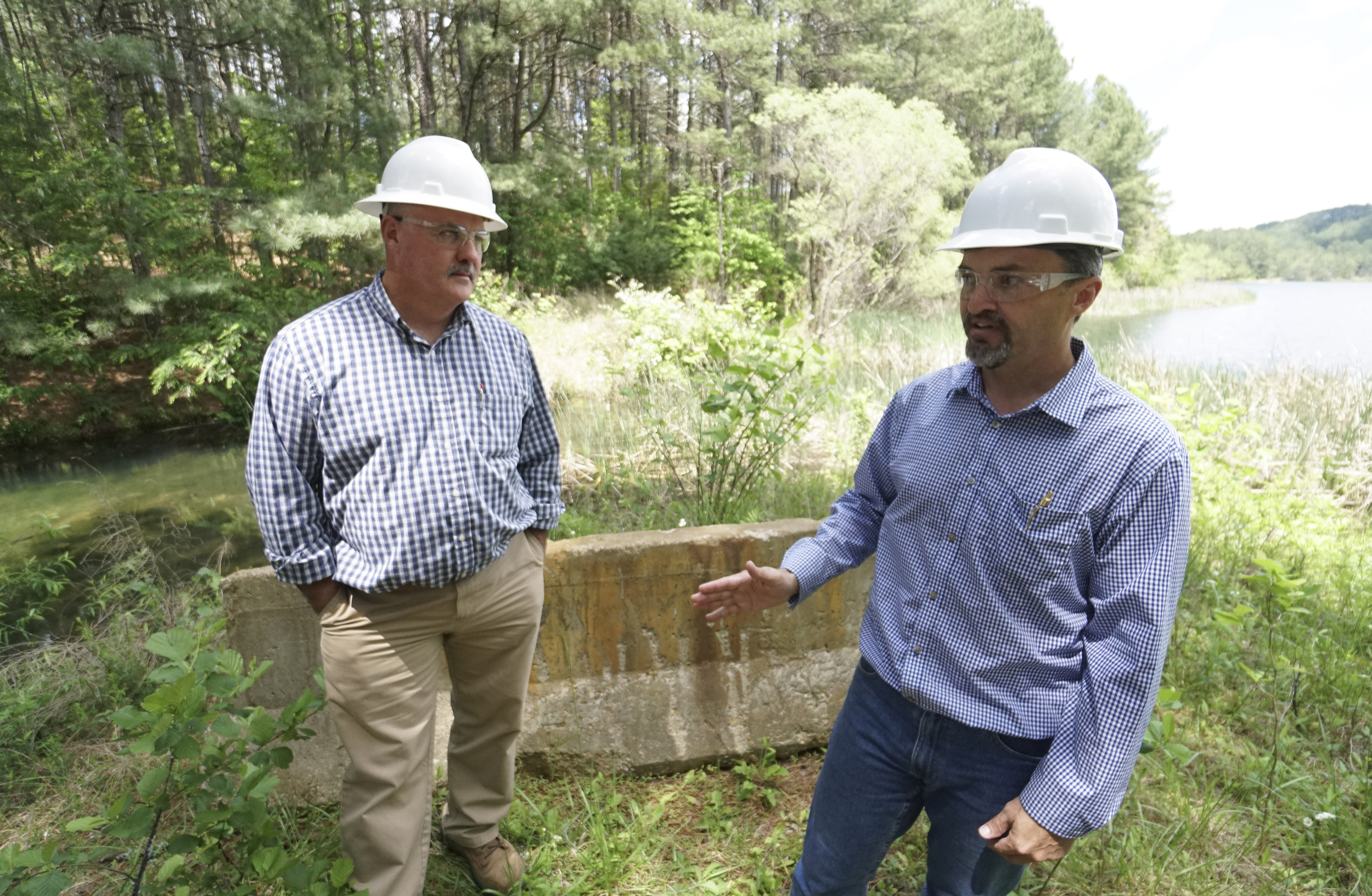 Site manager Scott Deal, left, listens as Rick Passmore, project manager, speaks about progress made to the Tailings Pond area in the Copper Basin.