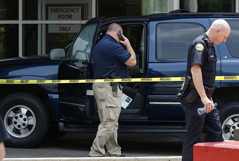 Police work the scene around a damaged vehicle parked at the Emergency Room entrance after a shooting victim arrived at Erlanger Hospital on Wednesday, May 11, 2016, in Chattanooga, Tenn.