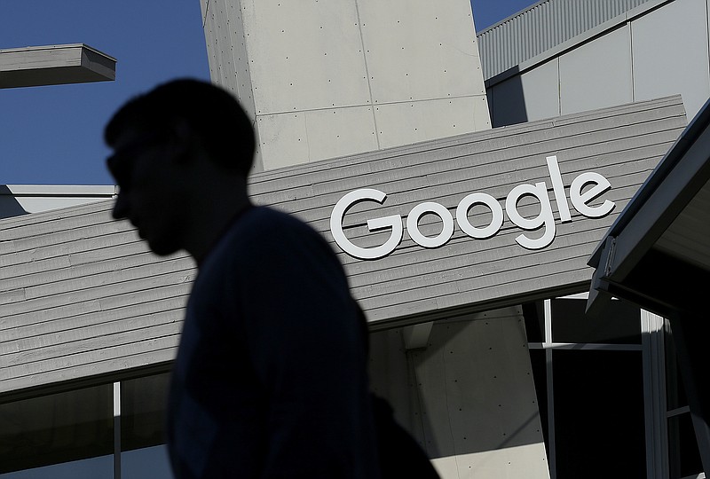 In this Nov. 12, 2015, file photo, a man walks past a building on the Google campus in Mountain View, Calif. Google said Wednesday, May 11, 2016, that it will ban ads from payday lenders, calling the industry "deceptive" and "harmful." Google said it will no longer allow ads for loans due within 60 days and will also ban ads for loans where the interest rate is 36 percent or higher. The ban is effective July 13. (AP Photo/Jeff Chiu, File)