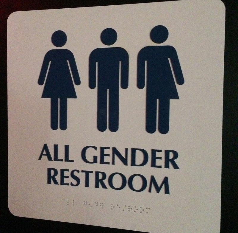 This May 11, 2014, photo shows an "All Gender Restroom" sign outside a bathroom in a bar in Washington. Confrontations have flared across the country over whether to protect or curtail the right of transgender people to use public restrooms in accordance with their gender identity.