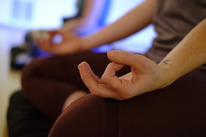 Lex Lepley curls her fingers during a meditation class at Clearspring Yoga on Wednesday, May 11, 2016, in Chattanooga, Tenn. Meditation is an important activity in Buddhism that helps to promote behaviors that are central to its teachings.