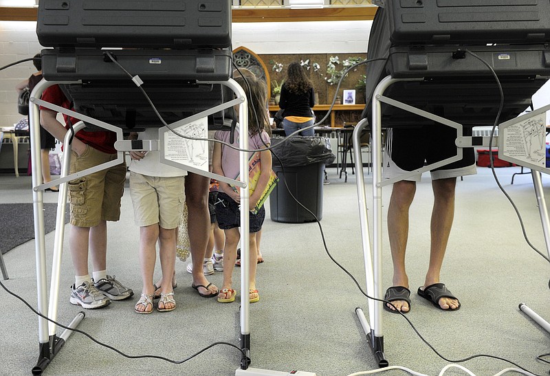 Primary voters in 2012 gather around a voting booth in Peoria, Ill.