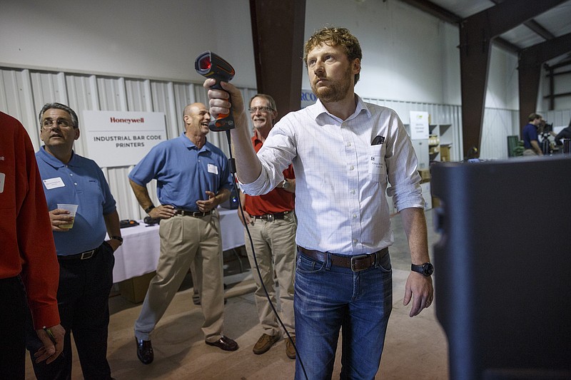 Greg Browning plays a game where he has to scan barcodes quickly during an open house at the company Barcom on Thursday, May 12, 2016, in Chattanooga, Tenn. The business, which makes equipment for managing and scanning bar codes, is celebrating its 25th year.