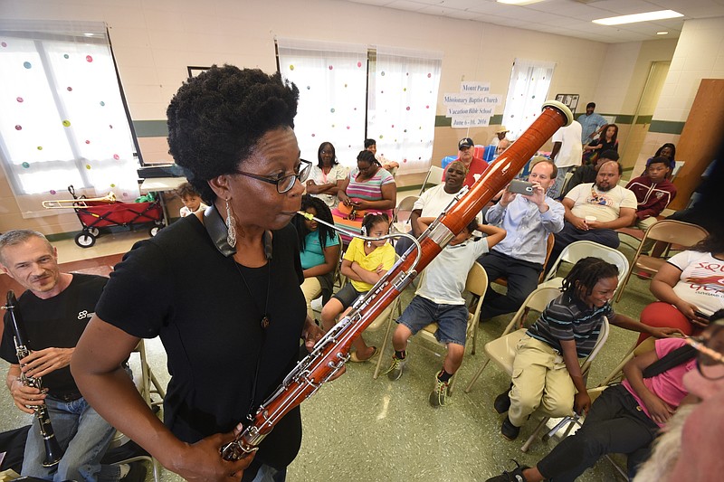 Maya Stone, one of five members of the CSO Wind Quintet, plays a sample sound for attendees at the Eastdale Youth Development Center on Thursday in a community engagement concert.
