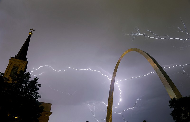 
              Lightning flashes in the sky behind the Gateway Arch, right, and the Old Cathedral, left, as a line of thunderstorms moves through St. Louis, Wednesday, May 11, 2016. Thousands of Ameren Corp. customers in the St. Louis area lost power after the strong thunderstorm hit the region. (AP Photo/Jeff Roberson)
            