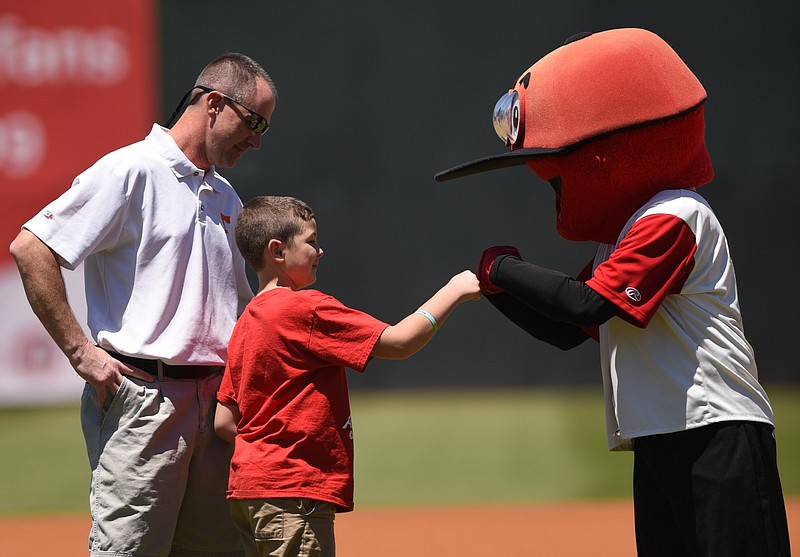 Mascot Louie greets Aiden Brown, center, and LifeForce flight paramedic Ray Cadwallader Sunday, May 15, 2016 before the Chattanooga Lookouts game at AT&T Stadium.