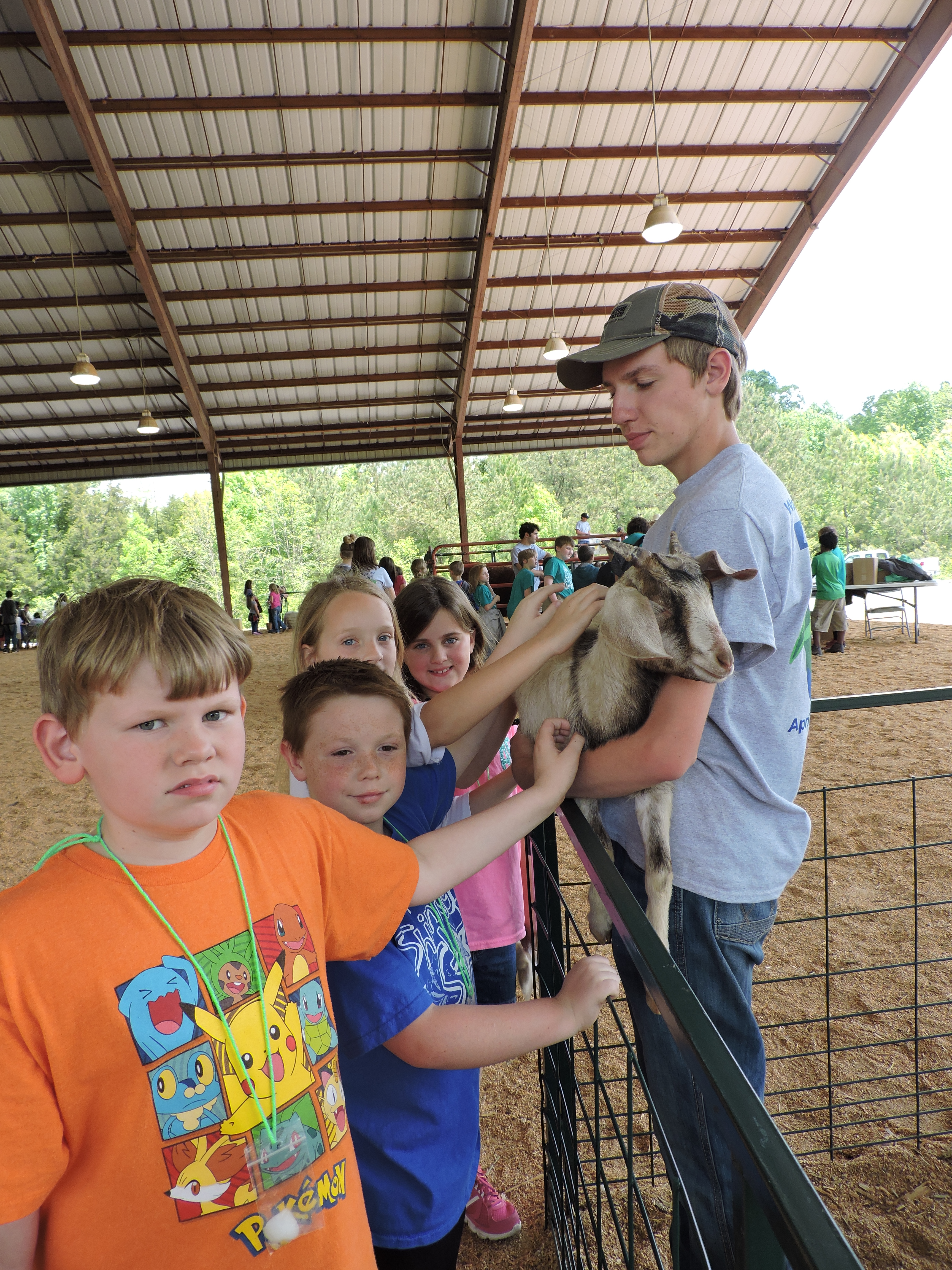 LaFayette High School Future Farmers of America volunteer PJ Doyle holds a goat for Cherokee Ridge Elementary students to pet. From left are Ely Stevens, Blake Price, Anna Daniel and Abby Brown.