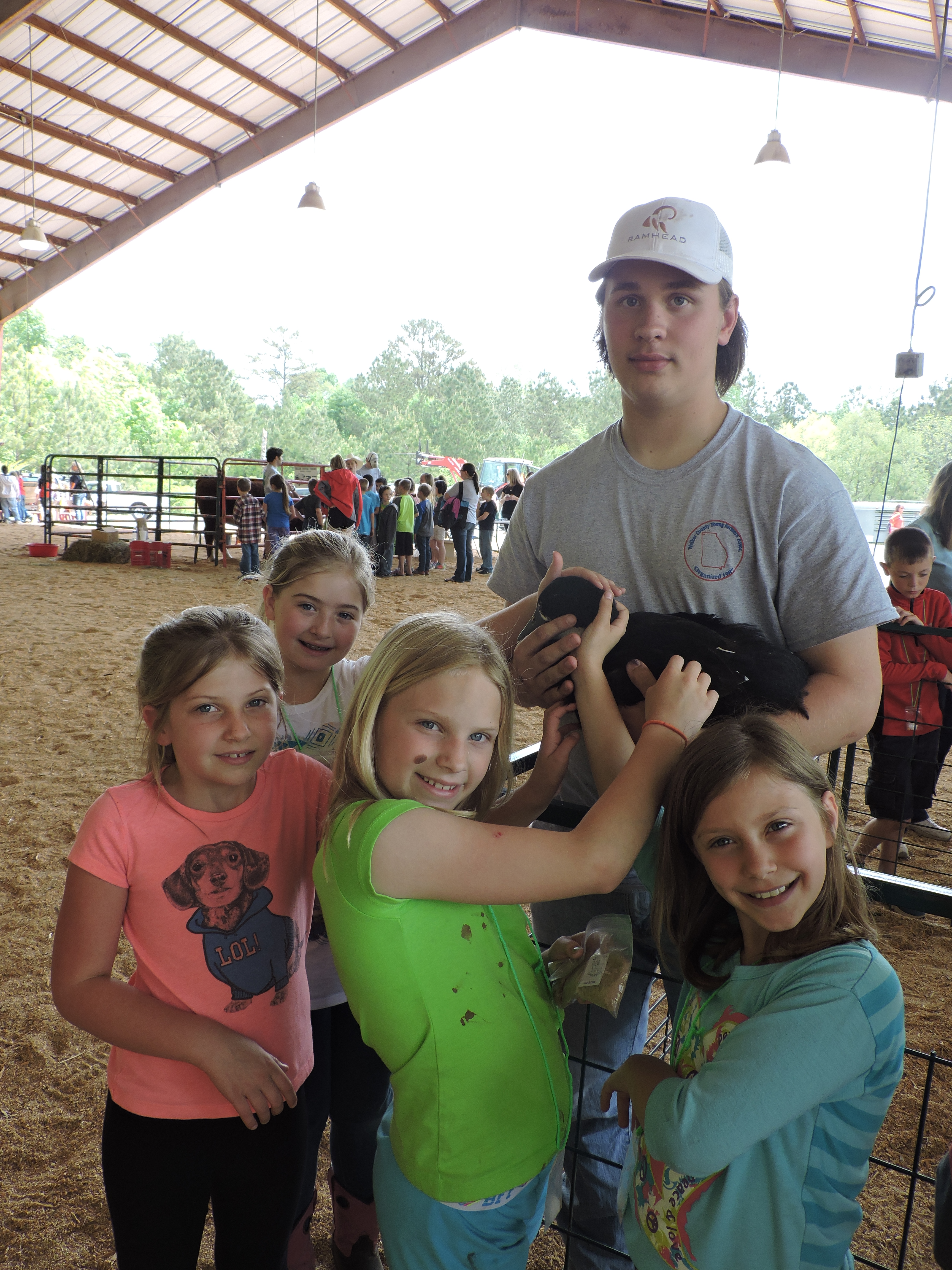 LaFayette High School Future Farmers of America volunteer Sam Snider holds a duck for students to pet. From left are Julie Harden, Kaylee Tatum, Channing Johnson and Brittley Brown.