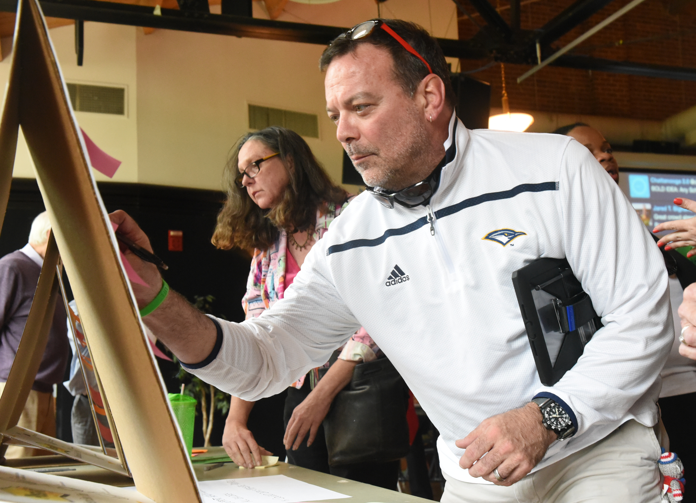 John Lennon, near right, teacher at Signal Mountain High, and Linda Bugg, teacher at Bess T. Shepherd Elementary, attach their suggestions to a board late Monday at the Chattanooga 2.0 open house event held at the Bessie Smith Cultural Center.