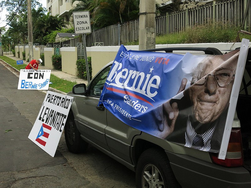 
              Jose Hernandez, a supporter of Senator Bernie Sanders, sets up signs outside an event where the Democratic presidential candidate is scheduled to speak in San Juan, Puerto Rico, Monday, May 16, 2016. Sanders arrives in Puerto Rico on Monday to talk about the U.S. territory’s worsening debt crisis ahead of the June 5 primary. (AP Photo/Danica Coto)
            