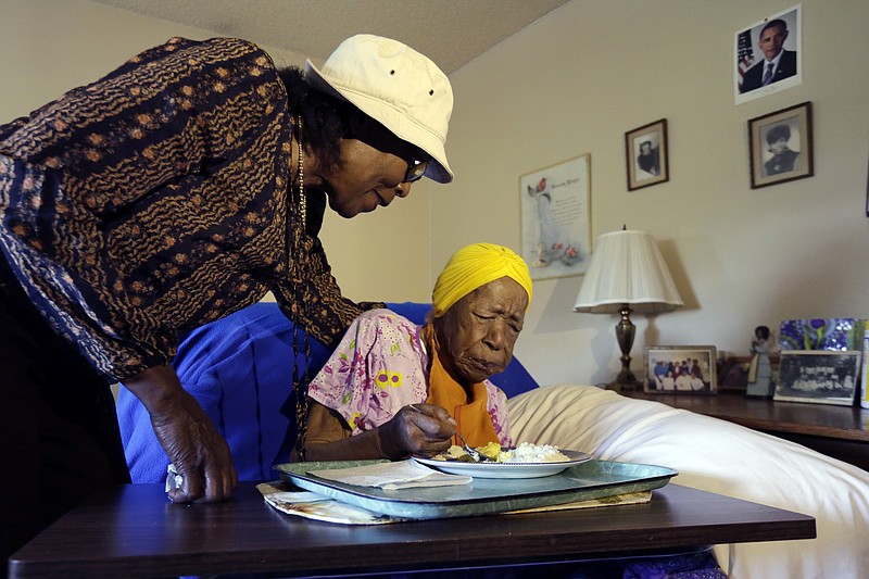 In this Monday, June 22, 2015, photo, Lois Judge, left, helps her aunt Susannah Mushatt Jones, during breakfast in Jones' room at the Vandalia Avenue Houses, in the Brooklyn borough of New York. Jones, the world's oldest person, has died in New York at age 116. Robert Young, a senior consultant for the Gerontology Research Group, says Jones died at a senior home in Brooklyn Thursday night, May 12, 2016. He said she had been ill for the past 10 days. 