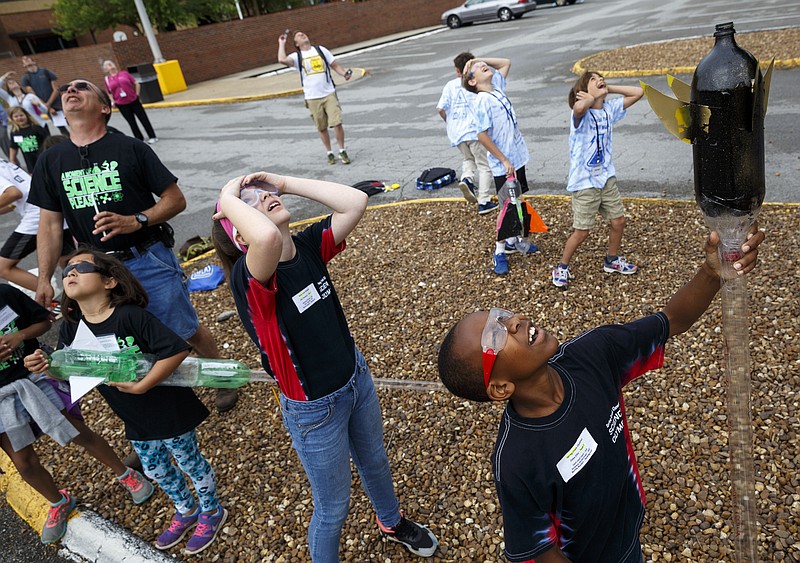 Students watch as a pressurized water rocket falls from teh sky after its launch during the 10th annual regional Elementary Science Olympiad at Chattanooga State Technical Community College on Tuesday, May 17, 2016, in Chattanooga, Tenn. Hundreds of elementary students competed in science-based competitions that included egg drops, pressurized rockets, and bridge building.