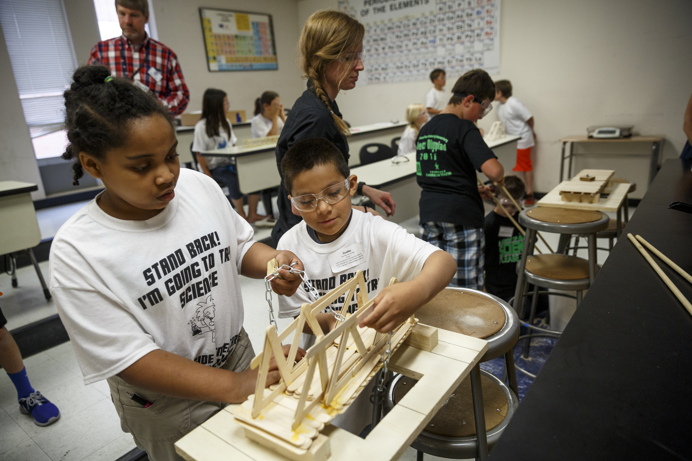 Brooklyn Clay, left, and Gueller Gonzales use a weight to test the strength of their popsicle stick bridge during the 10th annual regional Elementary Science Olympiad at Chattanooga State Technical Community College on Tuesday, May 17, 2016, in Chattanooga, Tenn. Hundreds of elementary students competed in science-based competitions that included egg drops, pressurized rockets, and bridge building.