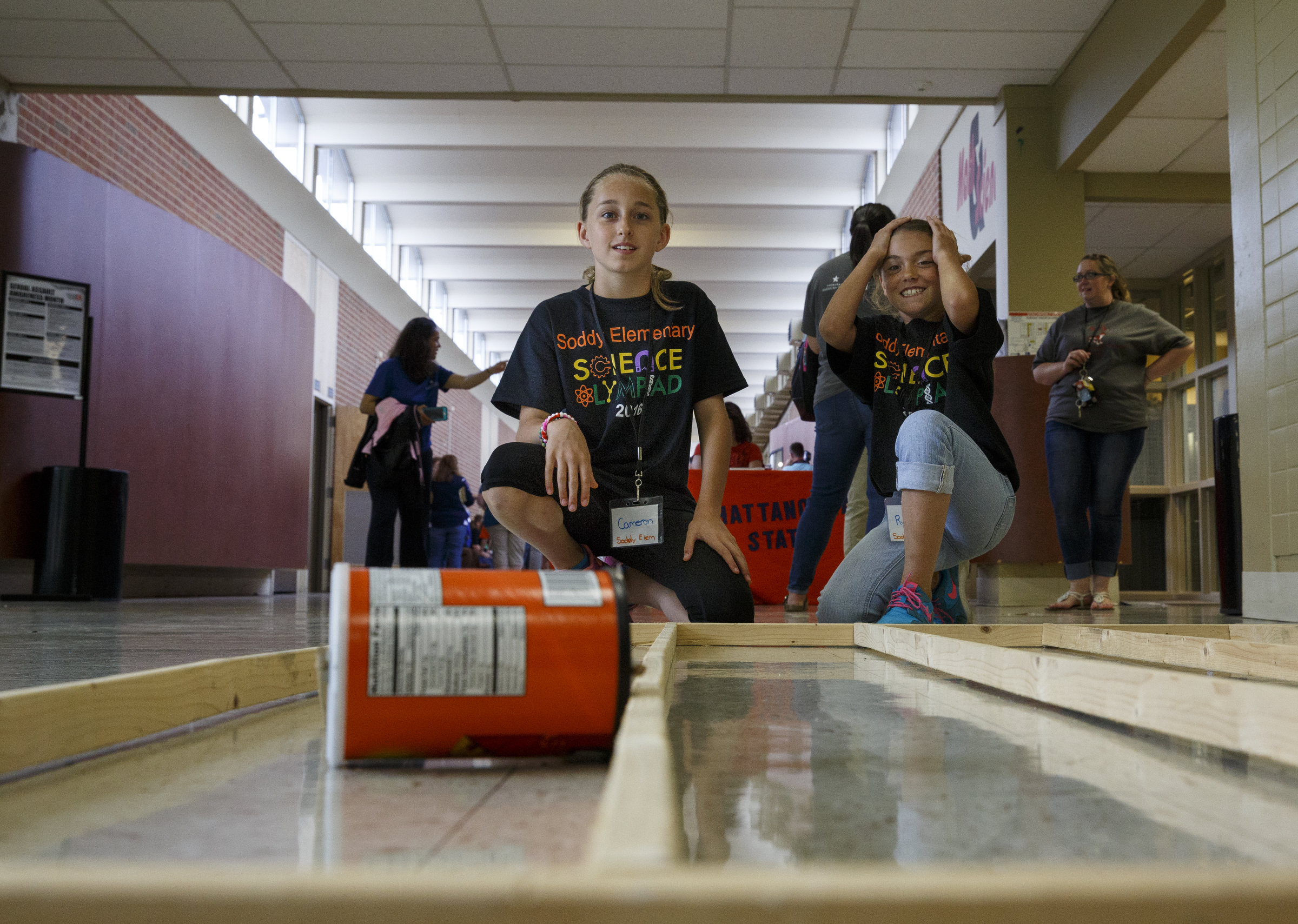 Cameron Varner, left, and Ryleigh Quarles watch their wound tin can roll in the tin can race during the 10th annual regional Elementary Science Olympiad at Chattanooga State Technical Community College on Tuesday, May 17, 2016, in Chattanooga, Tenn. Hundreds of elementary students competed in science-based competitions that included egg drops, pressurized rockets, and bridge building.