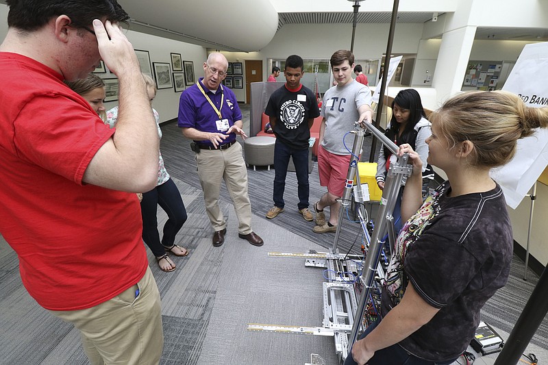 Doug Eaton, purple, speaks to Red Bank High School students as they participate in a robotics showcase at TVA in downtown Chattanooga on Wednesday, May 13, 2015.