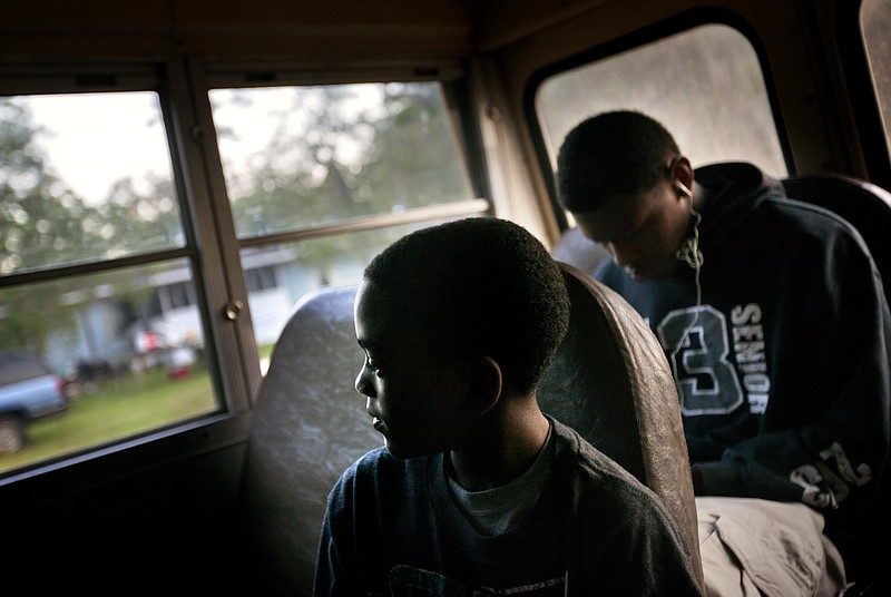 
              FILE - In this Wednesday, May 15, 2013 file photo, J.J. Wilson 9, rides a school bus to catch a ferry to the his school on the mainland from his home in the Hog Hammock community of Sapelo Island, Ga. Eight children catch a ferry in the morning to attend school on the mainland since the last school operating on the island closed in 1978. Slave descendants known as Gullah, or as Geechee in Georgia, live in small island communities scattered over 425 miles of the Southern Atlantic coast, where their ancestors worked on plantations before they were freed by the Civil War. (AP Photo/David Goldman)
            