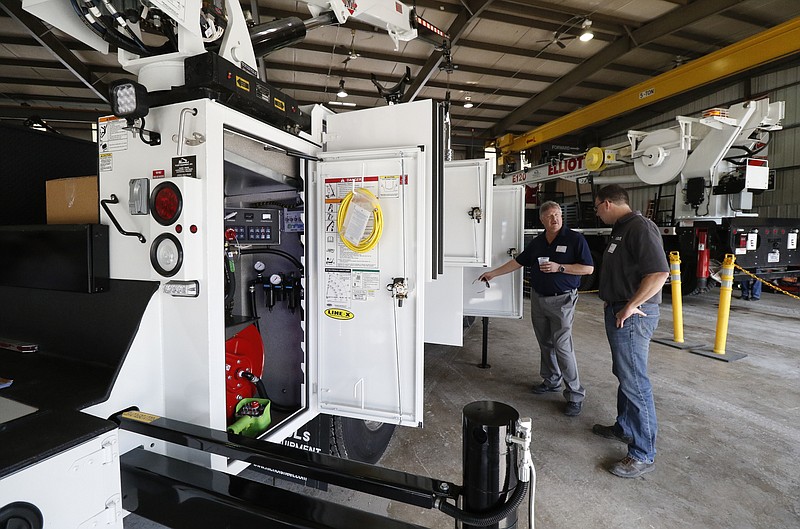 Staff Photo by Dan Henry / The Chattanooga Times Free Press- 5/18/16. Elliott Machine Works employees Joel Callis, left, and Jeran Pollock  look at outfitted trucks during an open house event at Nichols Fleet Equipment, Inc. on May 18, 2016 to celebrate 25-years in business. Nichols Fleet Equipment, Inc. is a family-owned business in Chattanooga that builds service trucks (like cherry-pickers, other heavy use trucks, etc.)