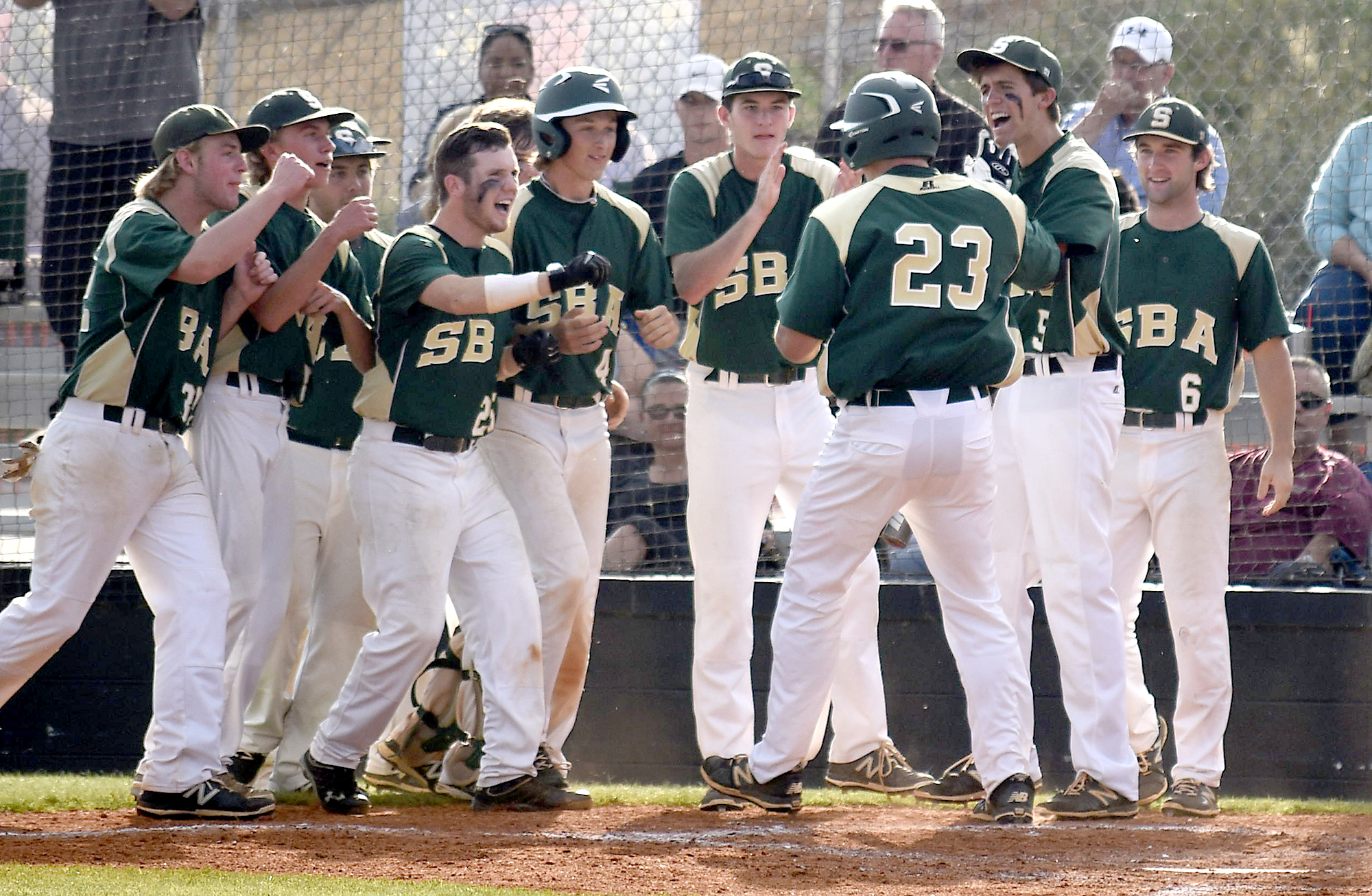 Silverdale's Blake Howard (23) is greeted by his teammates as he crosses home after hitting a three-run shot over the right field fence. The Silverdale Baptist Seahawks visited the Boyd-Buchanan Buccaneers in the Region 3-A championship baseball game May 18, 2016.