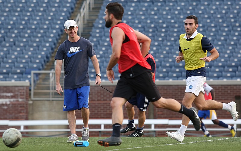 Chattanooga Football Club head coach Bill Elliott laughs after a water bottle gets knocked out of his hand during a scrimmage at practice on Thursday, May 8, 2014, in Finley Stadium. CFC will have their season opener on Saturday, May 10. 