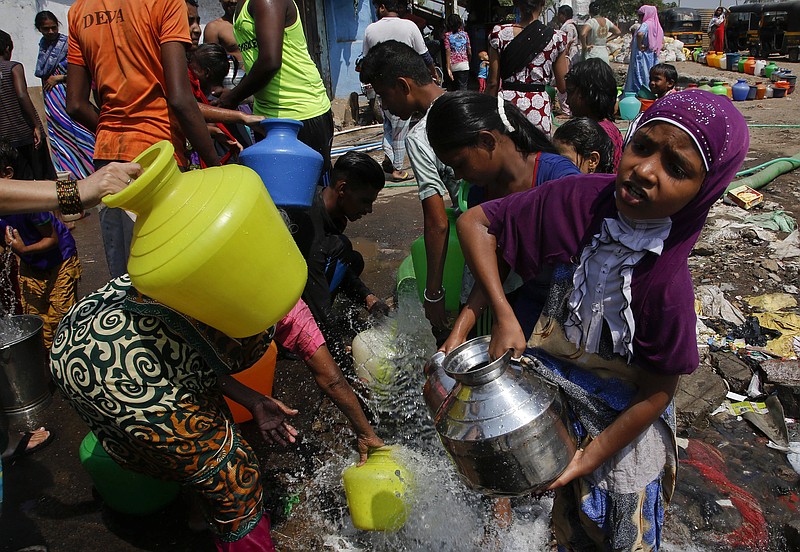 
              FILE - In this April 30, 2016 file photo, people collect water for non-drinking use as the same is pumped out from a construction site at a slum area in Mumbai, Maharashtra state, India. Earth’s heat is stuck on high. Federal scientists said the globe shattered monthly heat records for an unprecedented 12th straight month as April smashed the old record by half a degree. (AP Photo/ Rajanish Kakade, File )
            