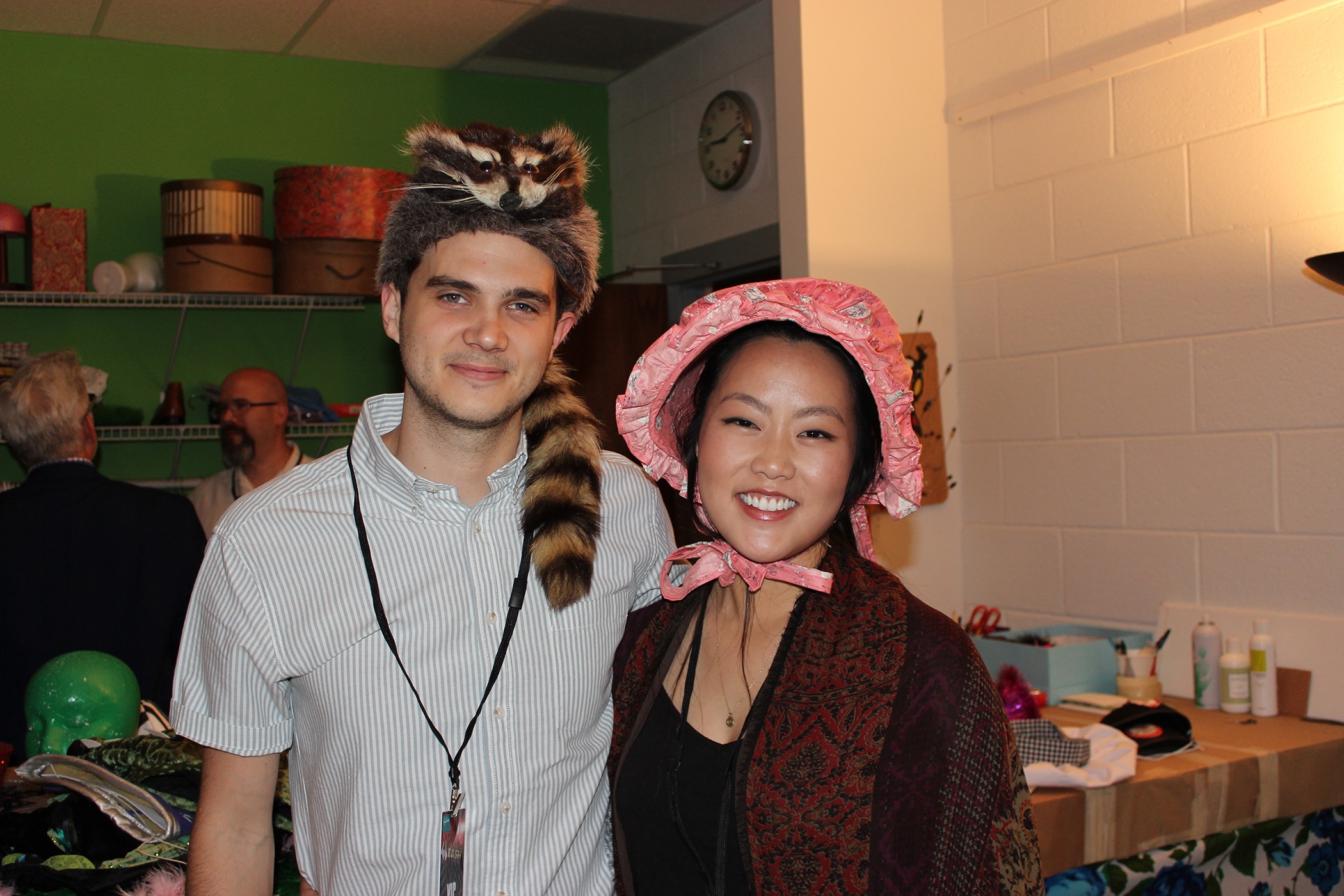 Shaun Webster tries on a cookskin cap while Elan Sok checks out a pioneer bonnet in the Costume Shop.