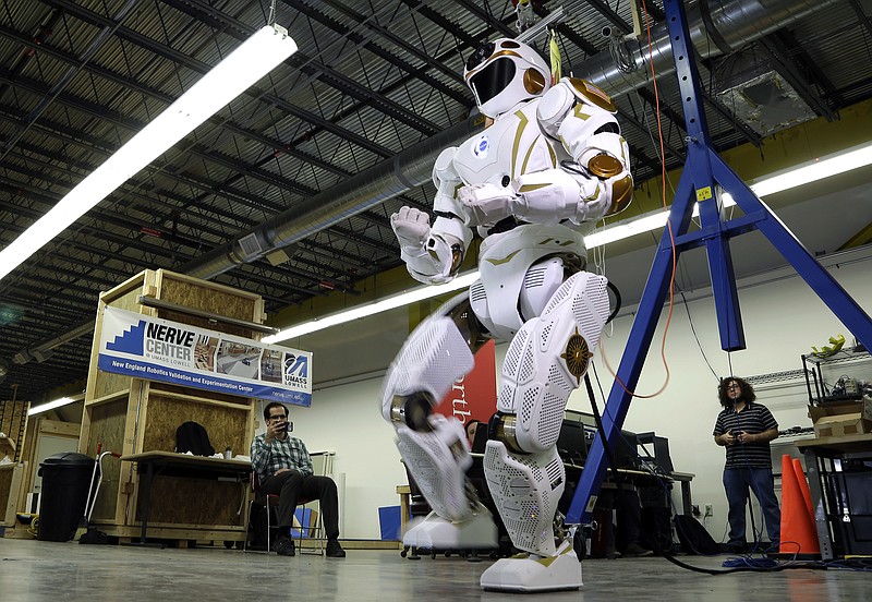 
              In this May 2, 2016 photo, researchers watch a six-foot-tall, 300-pound Valkyrie robot walk slowly at University of Massachusetts-Lowell's robotics center in Lowell, Mass. "Val," one of four sister robots built by NASA, could be the vanguard for the colonization of Mars by helping to set up a habitat for future human explorers. NASA spokesman Jay Bolden says the agency aims to get to Mars by 2035 and it’ll be the Valkyries or their descendants paving the way. (AP Photo/Elise Amendola)
            