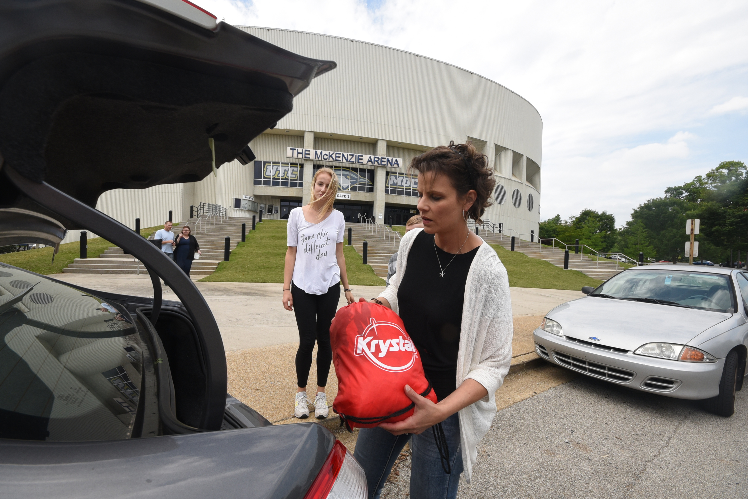 Cindy Larche, right, and Finni Eigenbrodt, a visitor from Germany, load donations of sportswear from the University of Tennessee at Chattanooga Mocs to share with Iraqi, Syrian and Sudanese refugees in Germany.