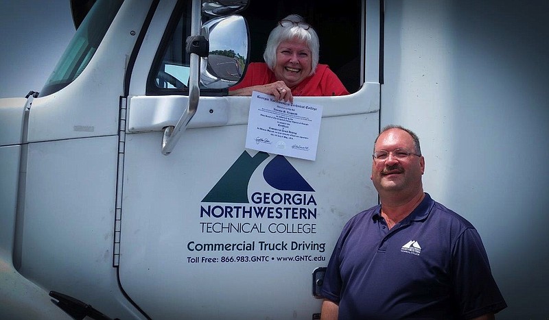 Veronica Longwith displays her certificate of completion of the Georgia Northwestern Technical College Commercial Truck Driving Course. Beside her tractor-trailer is Robert Browder, program director.