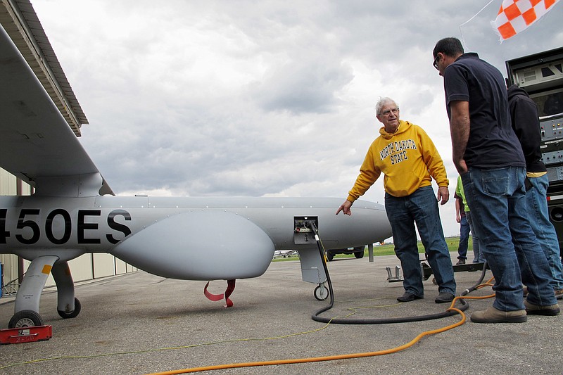 
              North Dakota State University agricultural researcher John Nowatzki points to a mechanical panel of a Hermes 450 drone before the aircraft took off from the Hillsboro, N.D. airport on Friday, May 20, 2016, to collect agriculture data. The drone can fly higher and longer than other aircraft currently being used for commercial purposes in the United States. The 20-foot long drone can fly for 20 hours. (AP Photo/Dave Kolpack)
            
